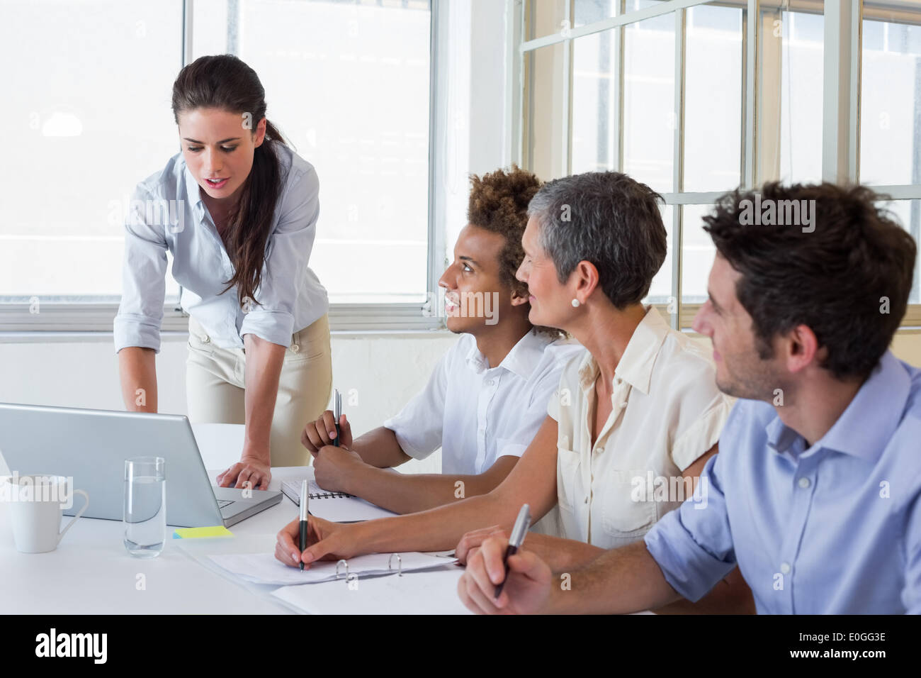 Business people using laptops and notebooks in meeting Stock Photo
