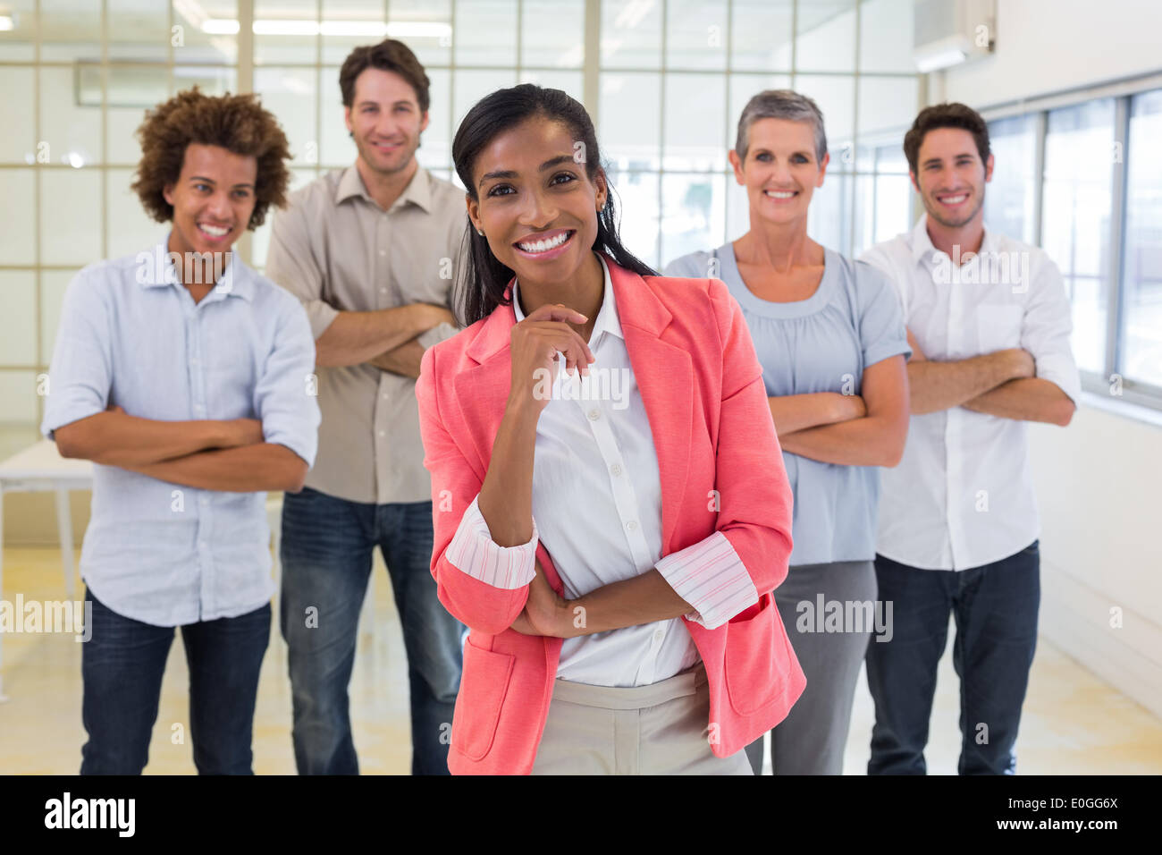 Well dressed workers with arms folded smiling at camera Stock Photo
