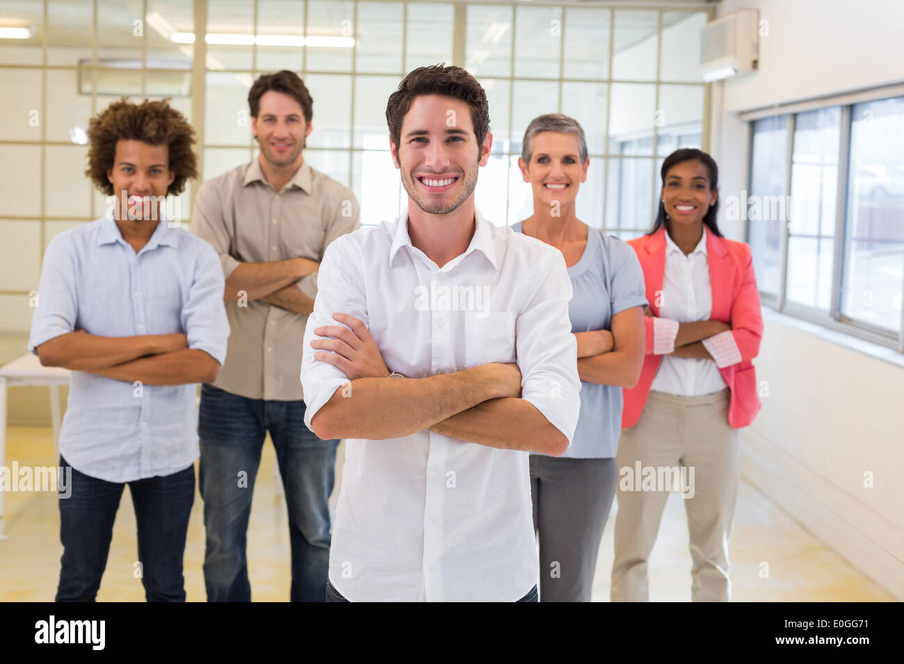 Workers with arms folded and smiling at camera Stock Photo