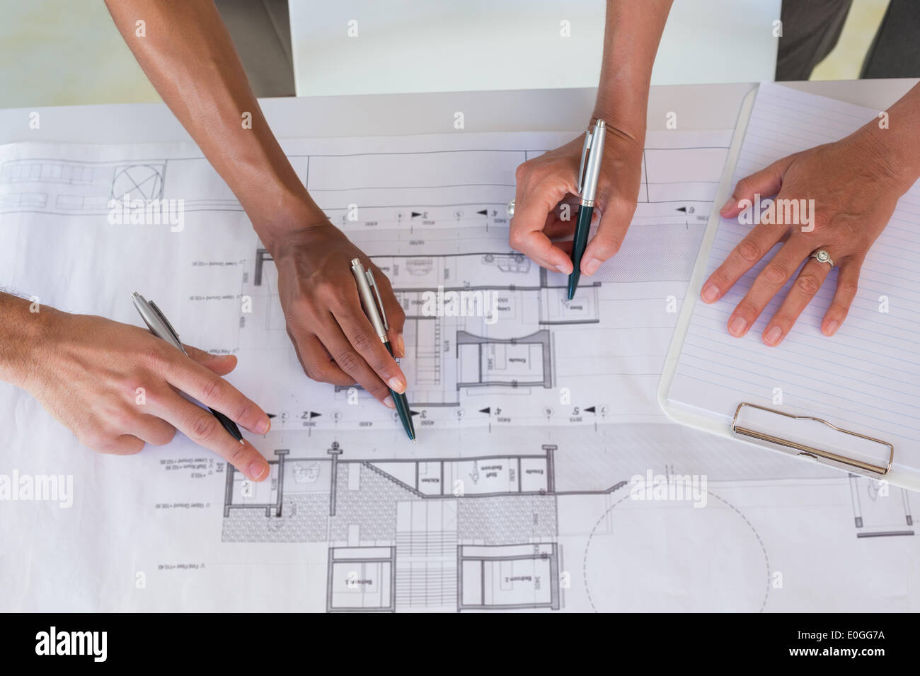 Team of architects going over blueprints Stock Photo - Alamy