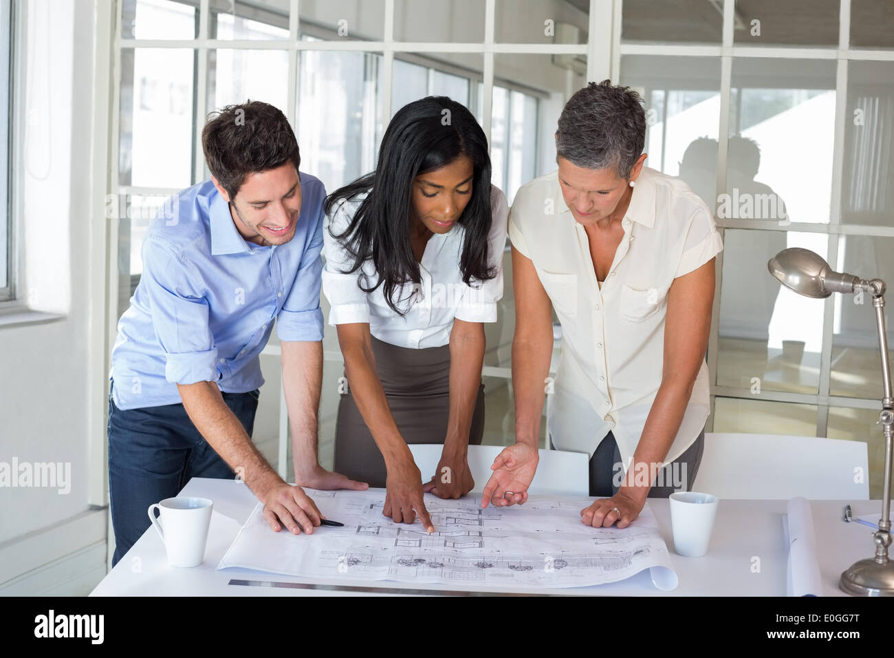 Three architects looking at blueprints Stock Photo