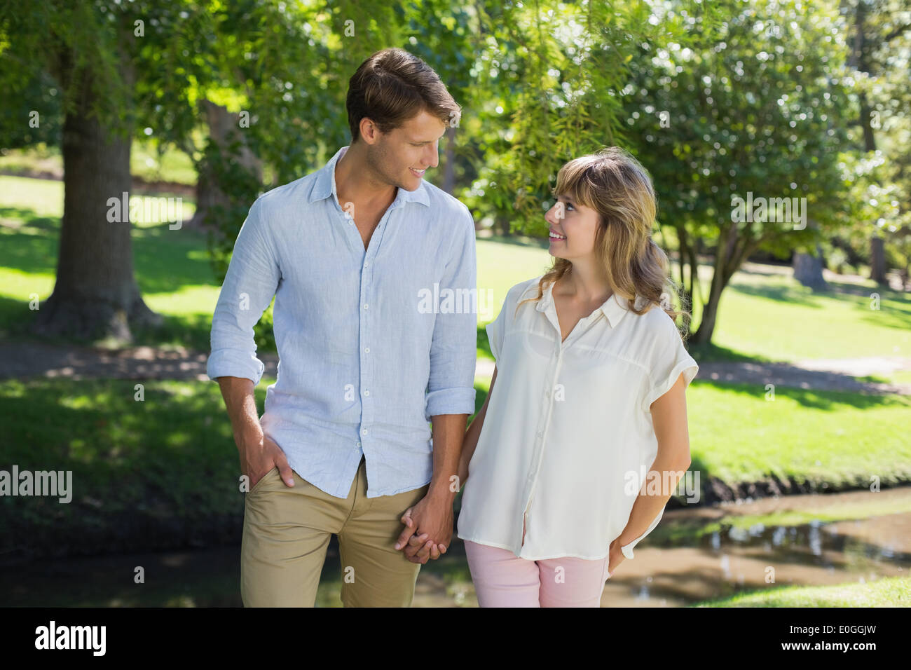 Cute couple walking hand in hand in the park Stock Photo - Alamy