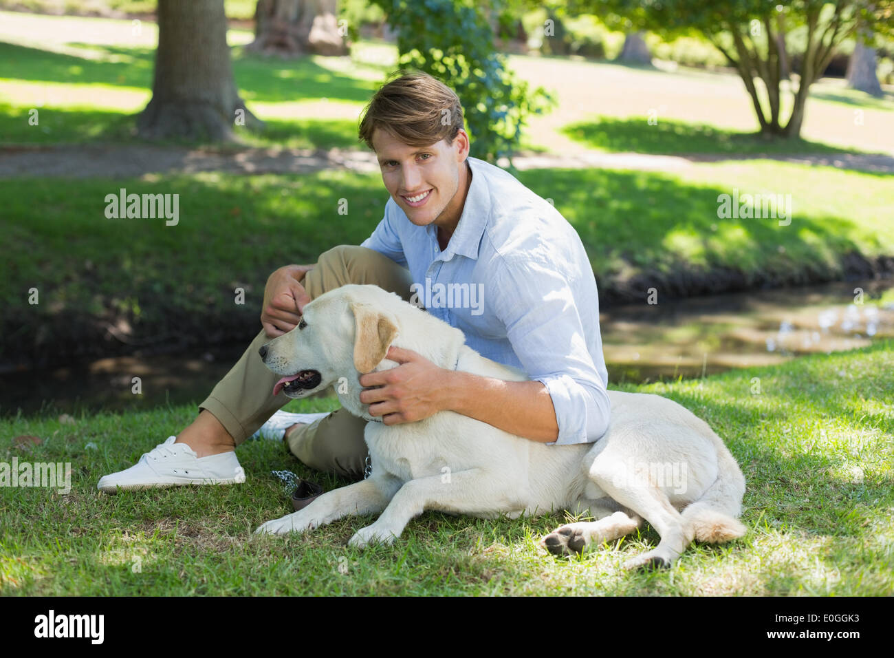 Labrador Man Handsome smiling man with his labrador in the park Stock Photo - Alamy