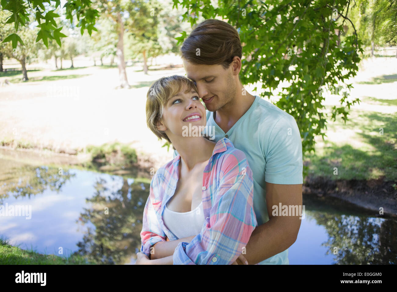 Affectionate young couple standing together in the park Stock Photo