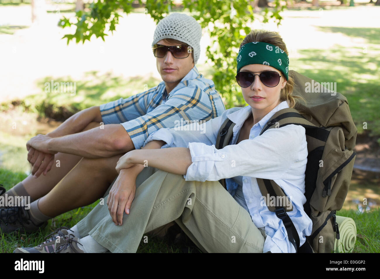 Active couple sitting down on a hike looking at camera Stock Photo