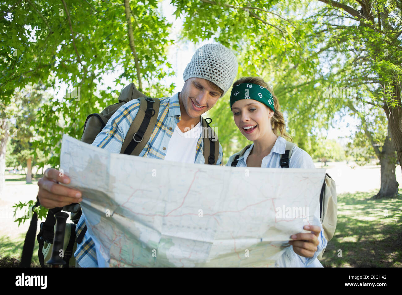 Active smiling couple on a hike consulting the map Stock Photo - Alamy