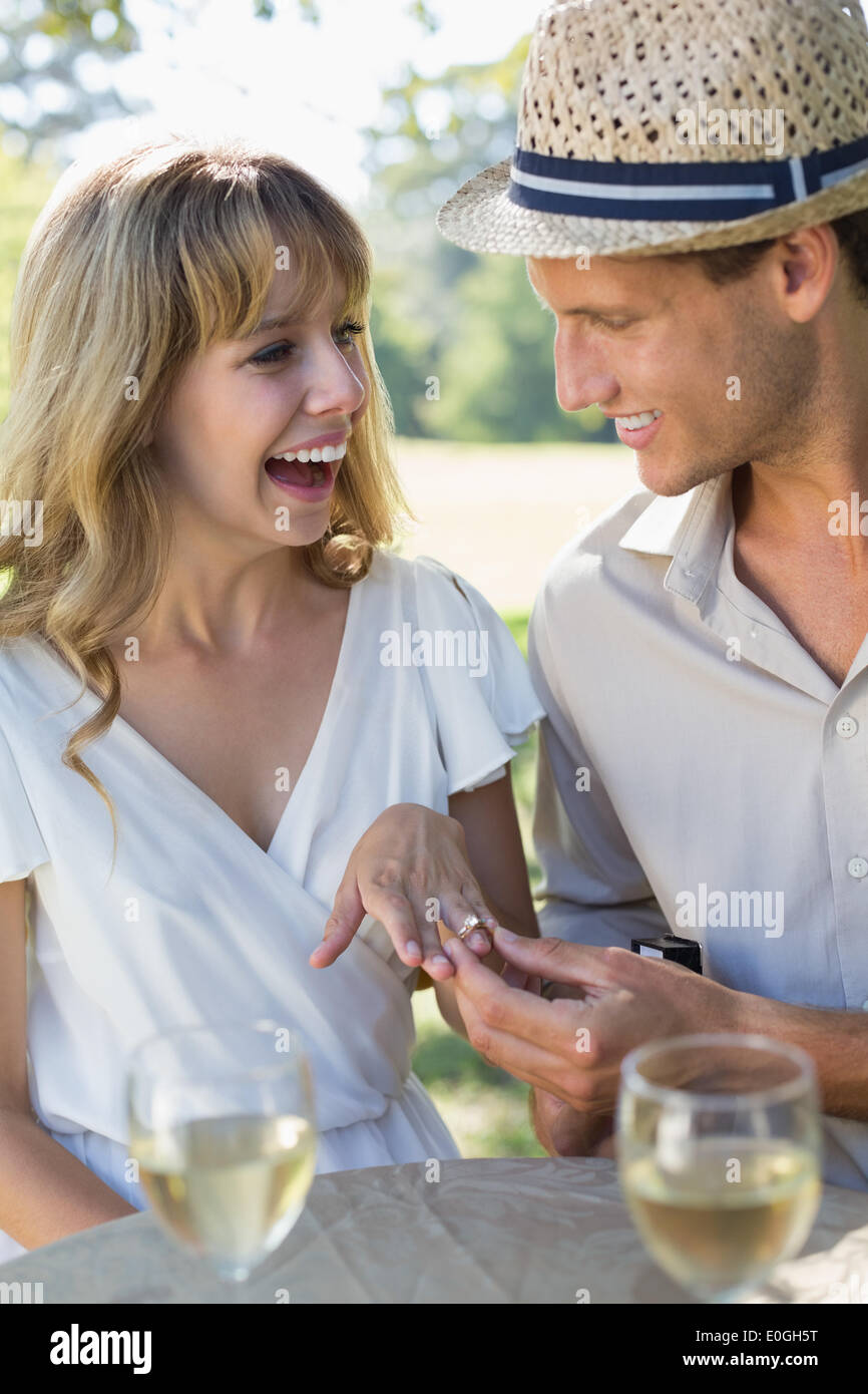 Man placing engagement ring on smiling fiancees finger Stock Photo - Alamy