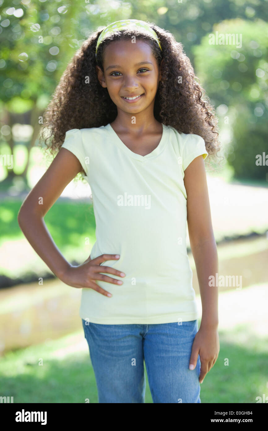 Young girl smiling at the camera in the park with hand on hip Stock ...
