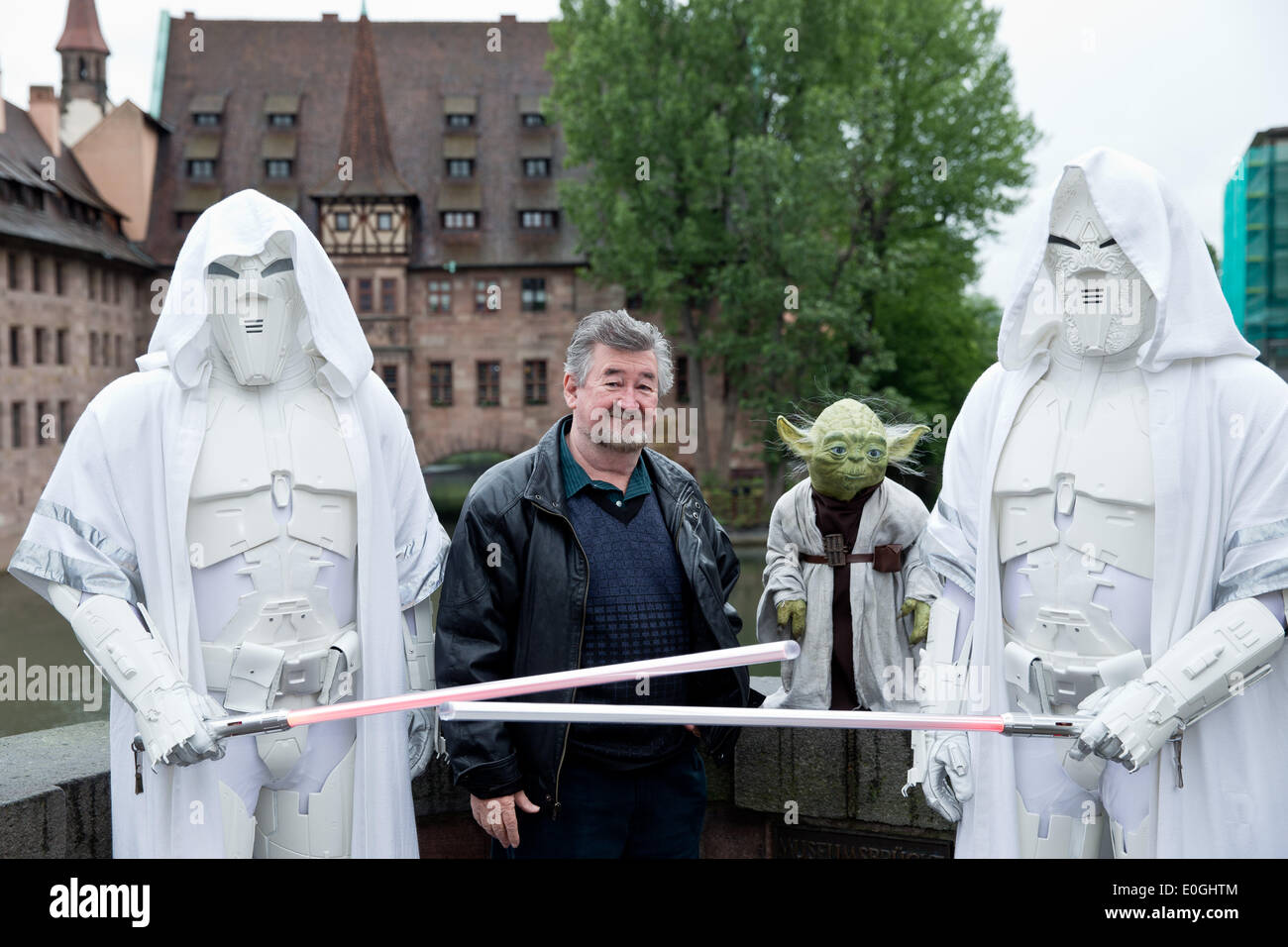 Nuremberg, Germany. 07th May, 2014. Make-up artist Nick Maley, one of the designers of Yoda from the science fiction film Star Wars stands with a Yoga figure and two other figures at the old town in Nuremberg, Germany, 07 May 2014. 64 year-old is planning a new museum for special effects, fantasy and science fiction films in Nuremberg. Photo: DANIEL KARMANN/dpa/Alamy Live News Stock Photo
