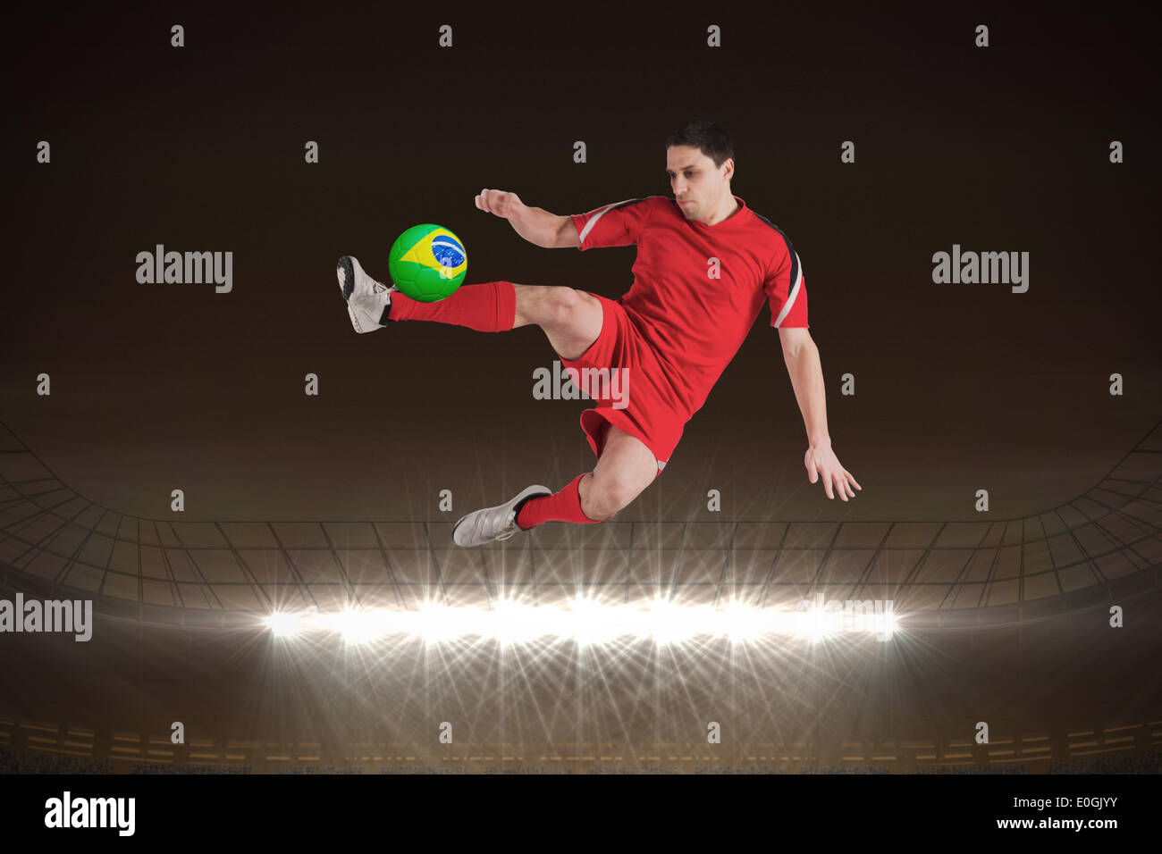 Fit football player jumping and kicking Stock Photo Alamy