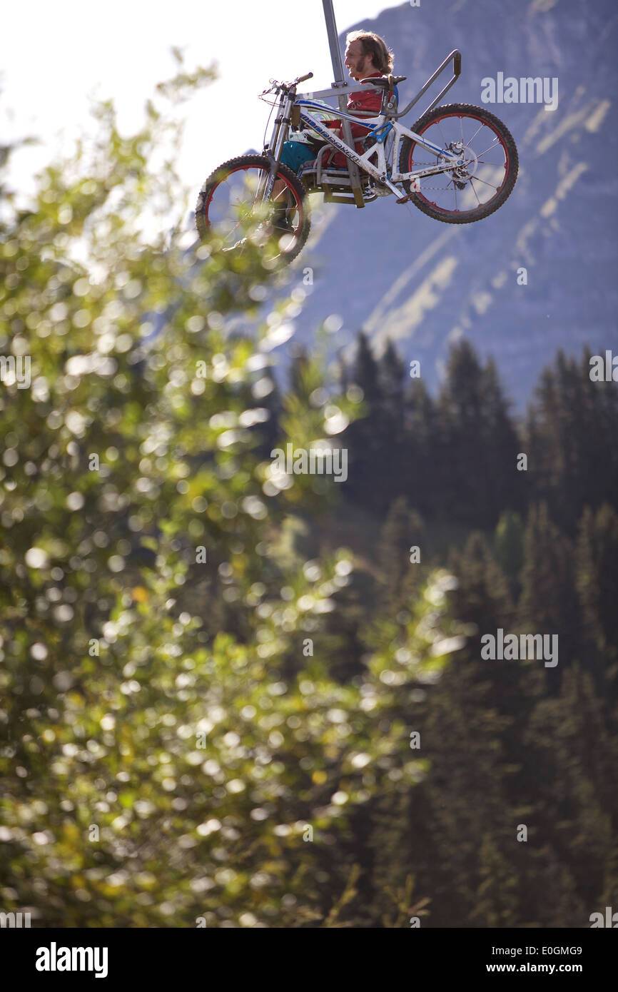 Downhill mountain biker in a chairlift, Morzine, Haute-Savoie, France Stock Photo