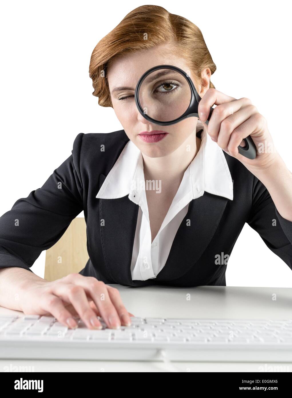 Redhead businesswoman looking through magnifying glass Stock Photo - Alamy