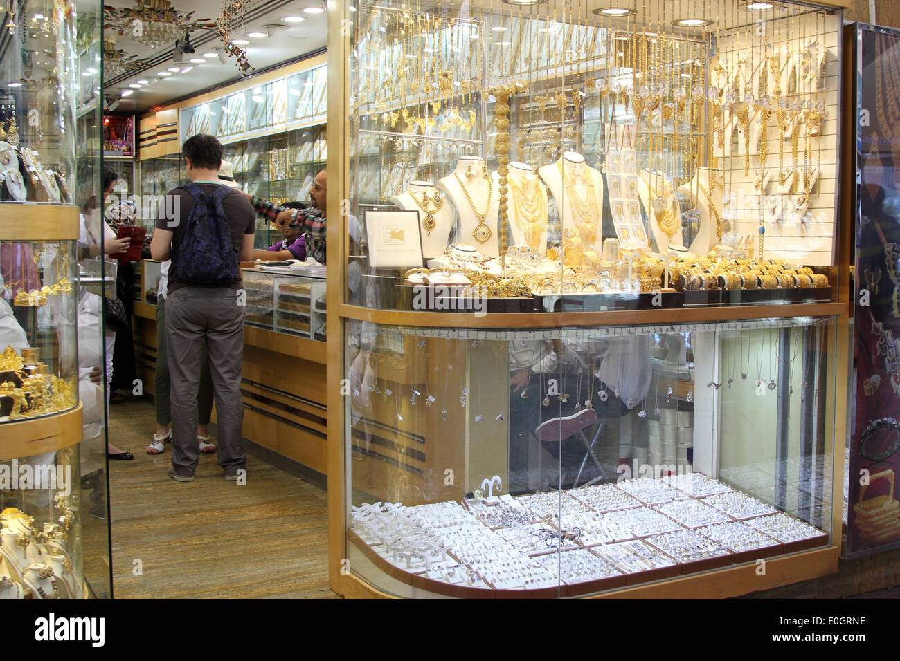 Customers examine the goods in a shop in the gold souk in Dubai, United Arab Emirates. Stock Photo
