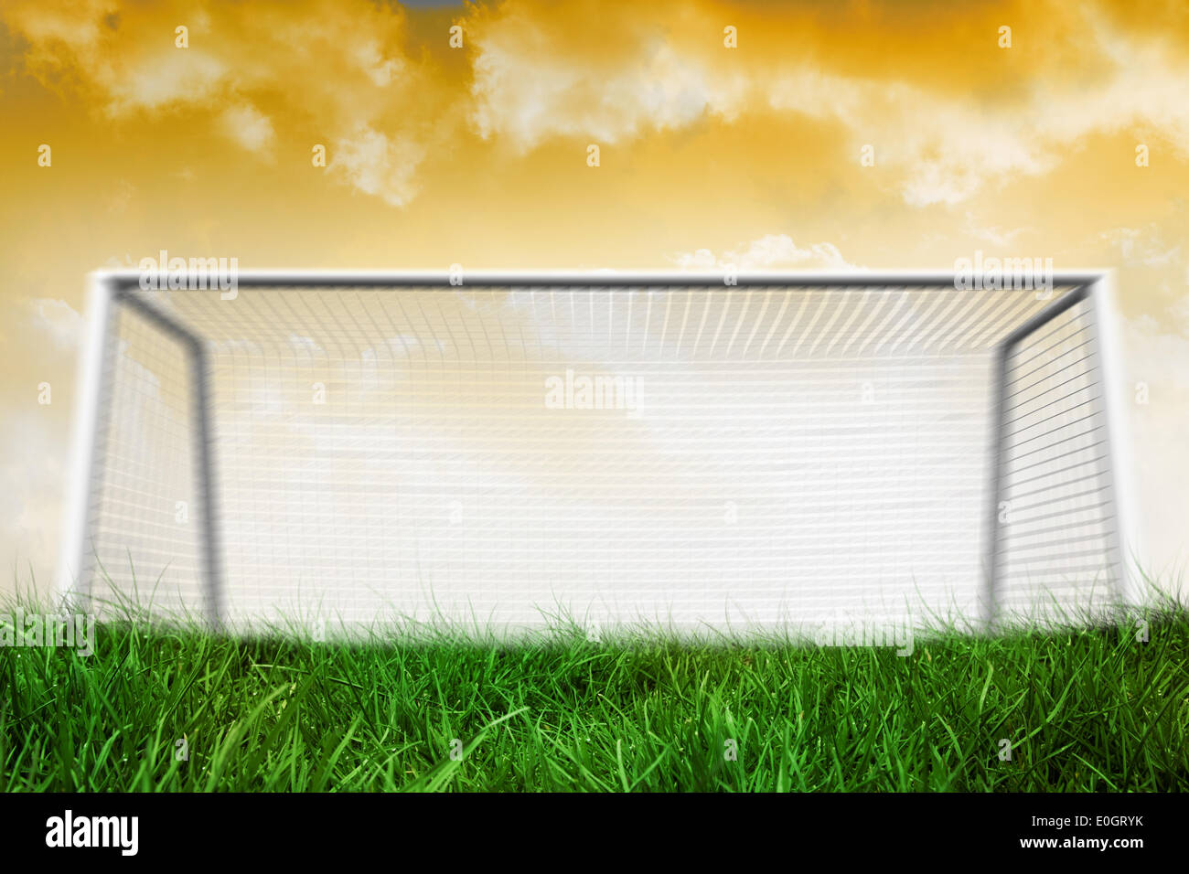 Goalpost on grass under yellow sky Stock Photo
