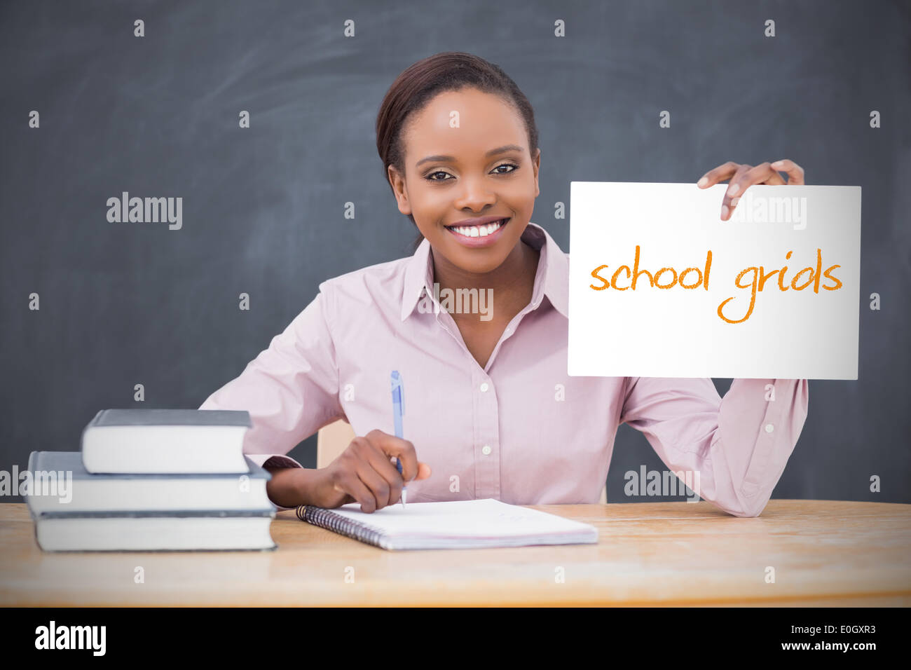 Happy teacher holding page showing school grids Stock Photo