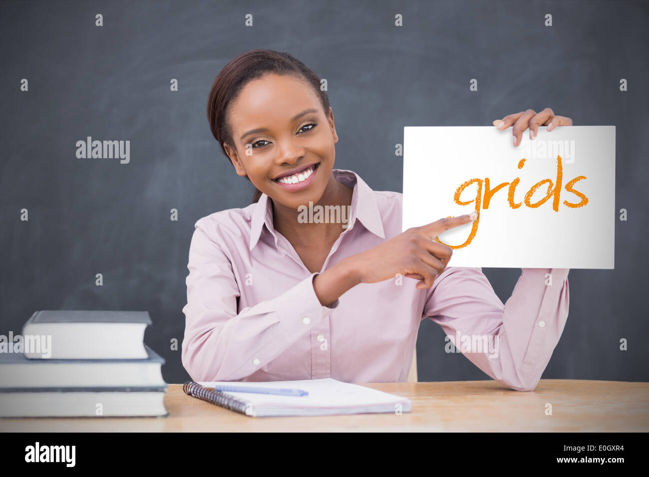 Happy teacher holding page showing grids Stock Photo