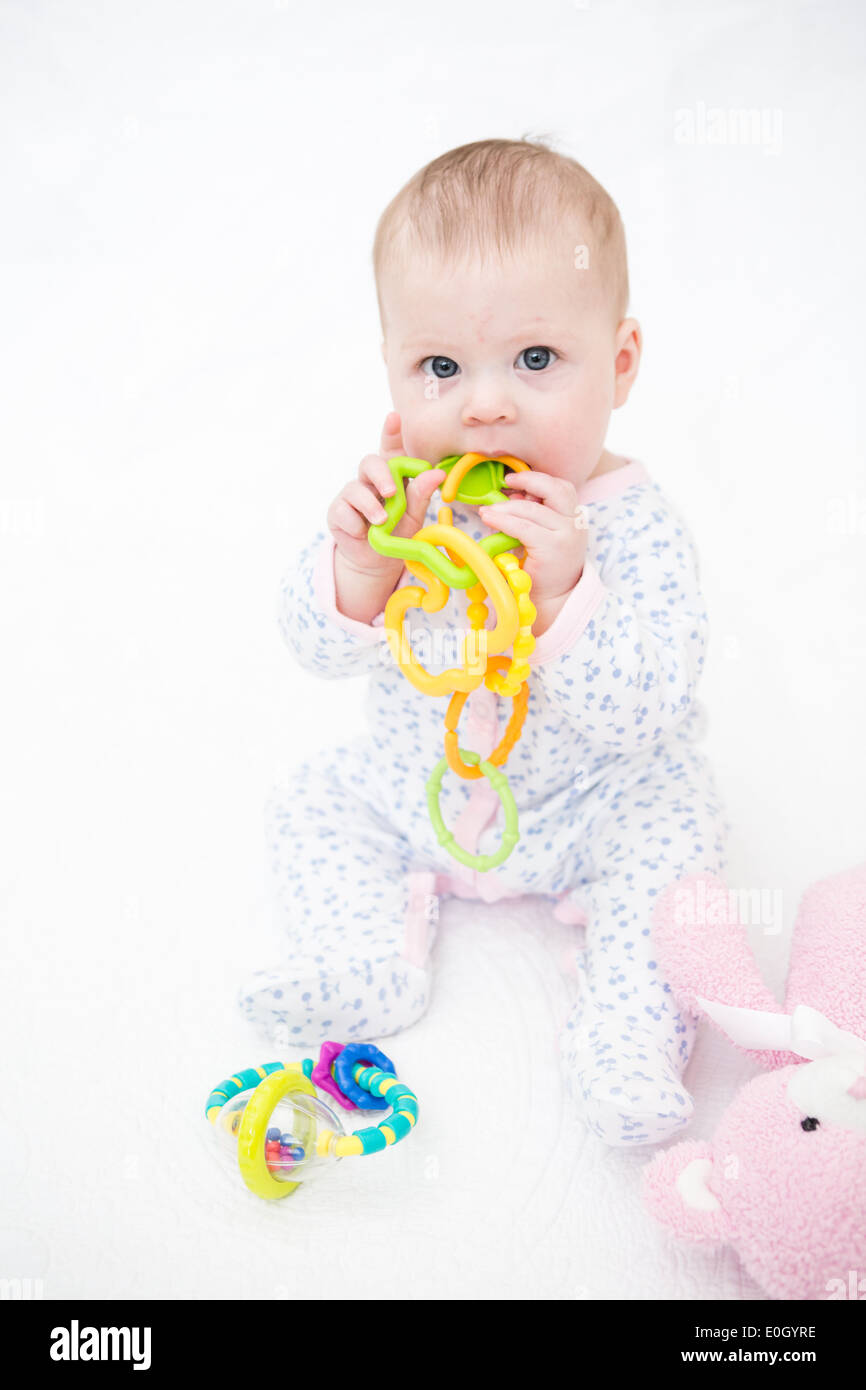 Cute baby girl playing on a white blanket Stock Photo - Alamy