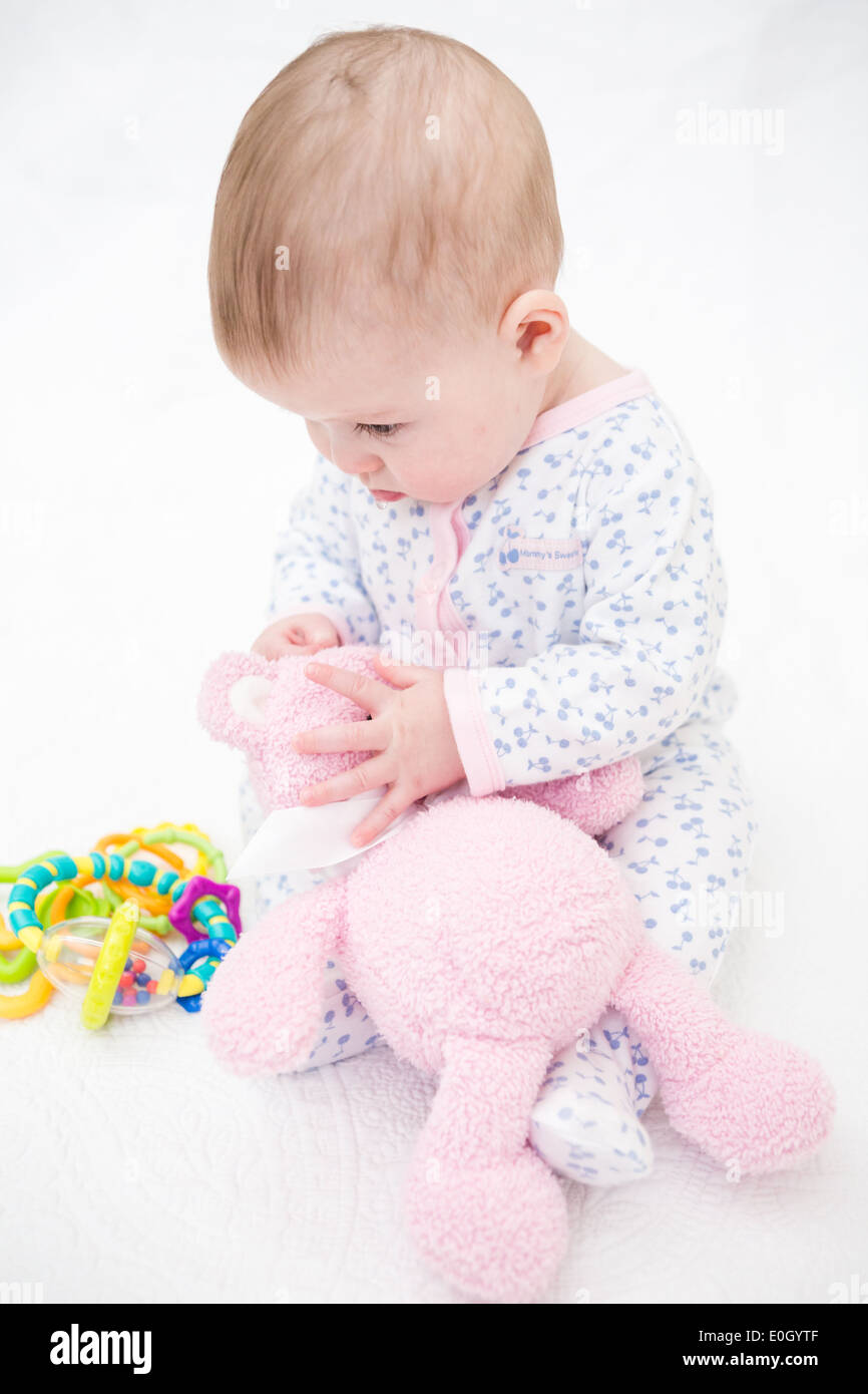 Cute baby girl playing on a white blanket Stock Photo - Alamy