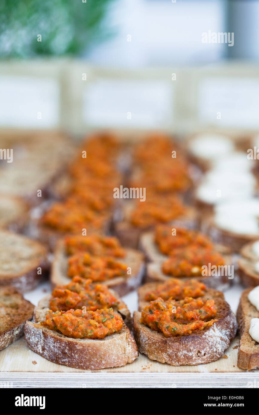 Closeup of bruschetta appetizers with savoury paste topping presented in rows Stock Photo