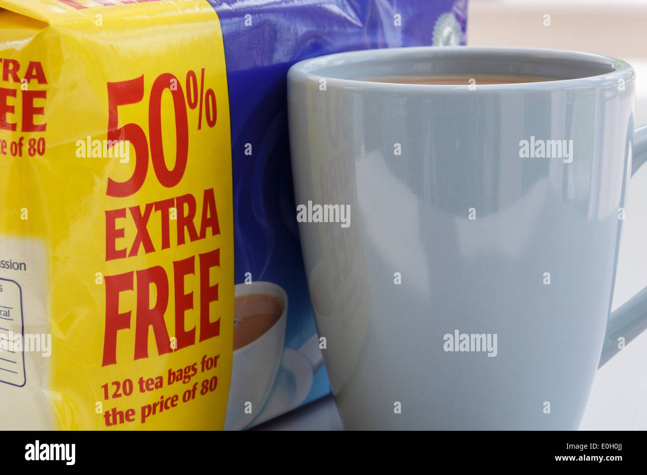 Good value discounted packet of Tetley's teabags with yellow label stating 50% extra free beside a mug of tea. England, UK, Britain Stock Photo