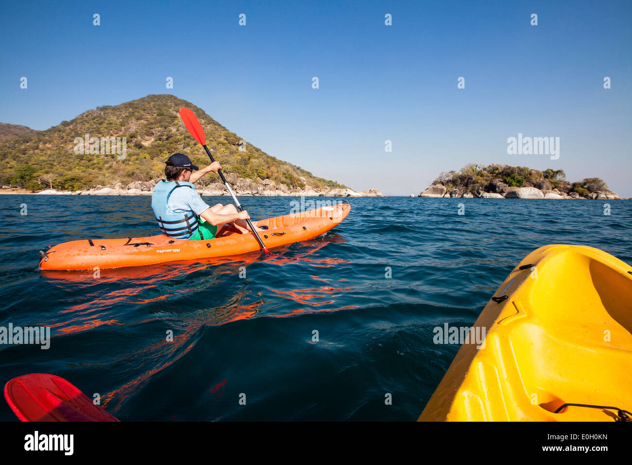 A man paddling in a canoe at Cape Maclear, Otters Point, Lake Malawi, Africa Stock Photo