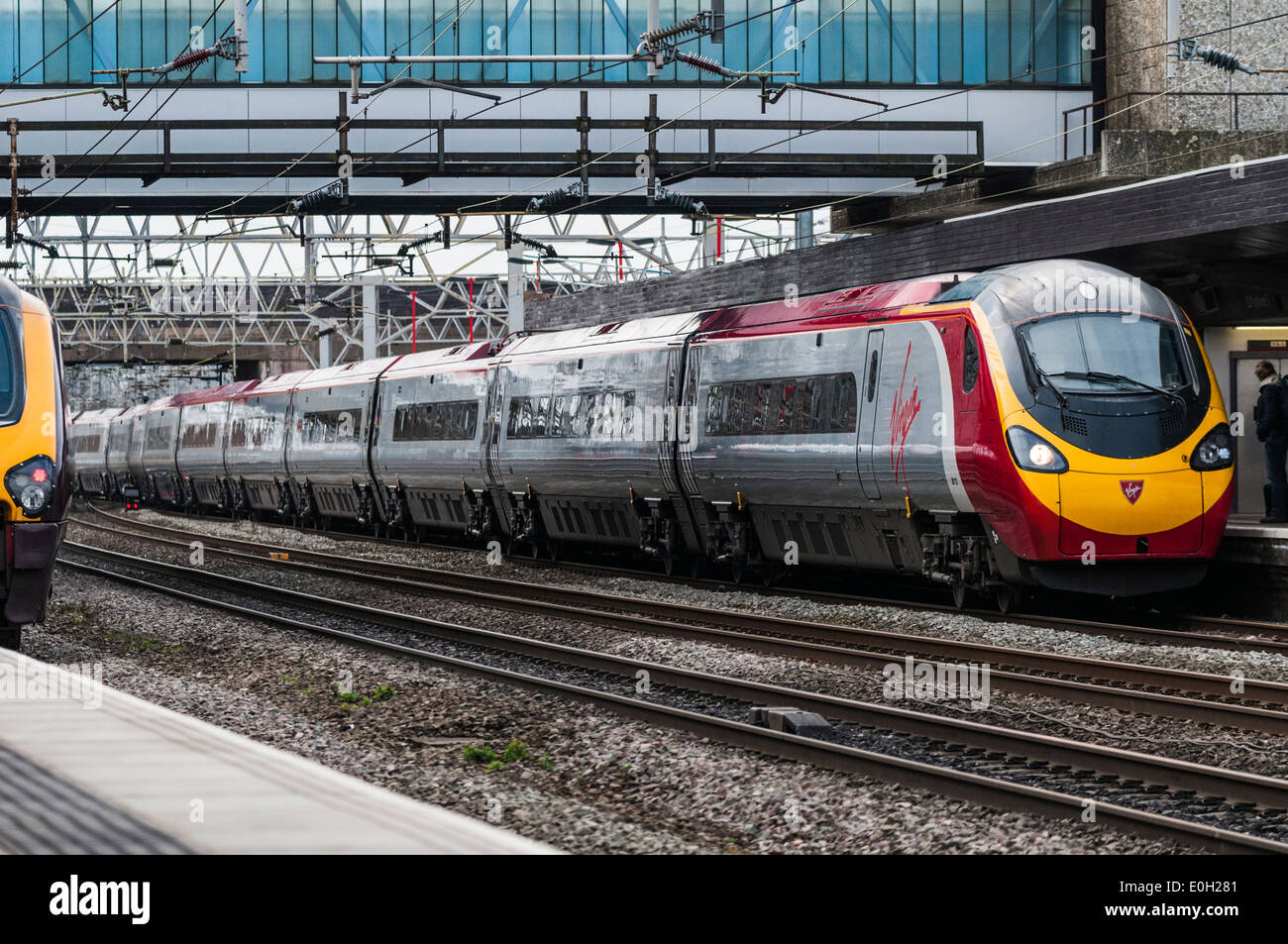 Virgin Pendolino express passenger train pulling into the platform at