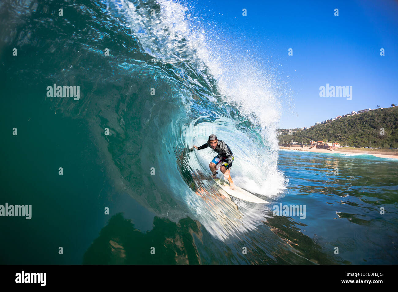 Surfing Surfer tube rides hollow blue crashing ocean wave swimming water action photo. Stock Photo