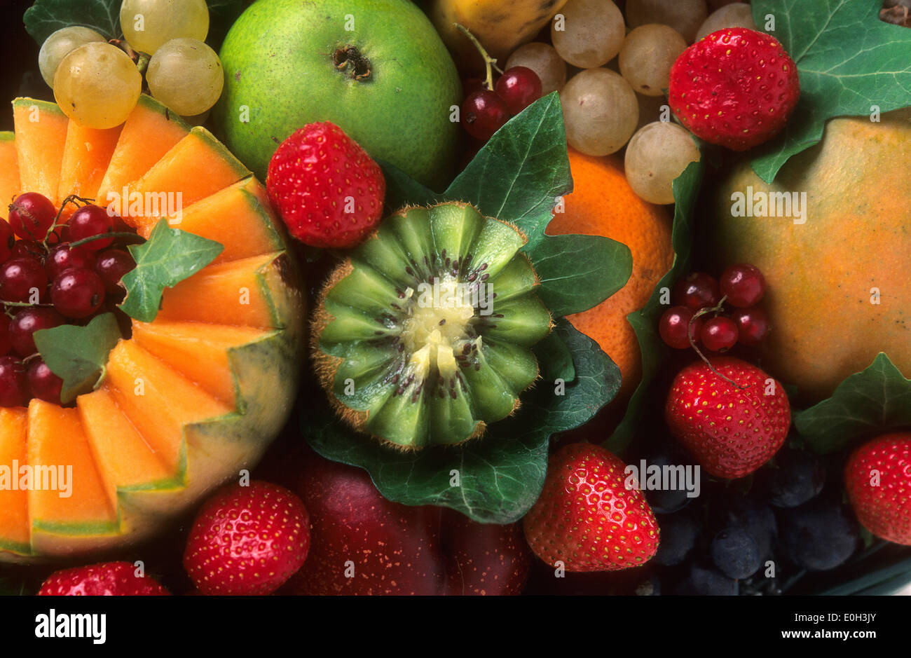 Variety of fruits, kiwi, grapes, melon, red currants, strawberries, pear Stock Photo