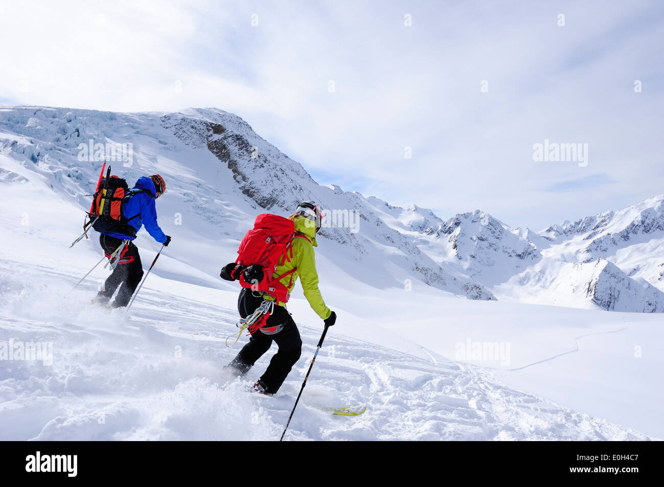 Two skiers downhill skiing from mount Wildspitzer on glacier, Oetztal Alps, Tyrol, Austria Stock Photo