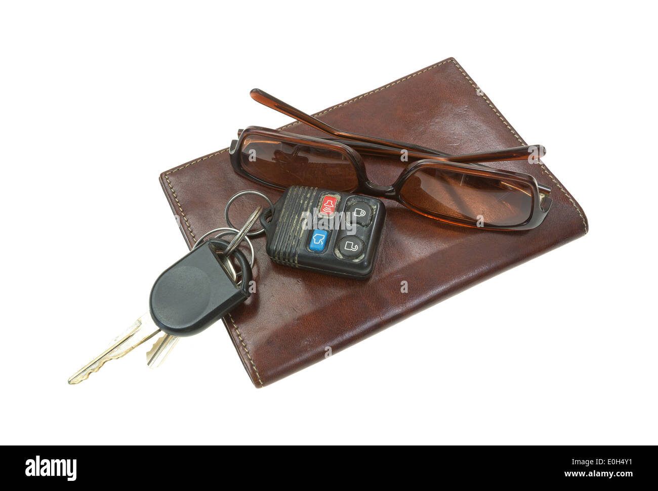 A pair of used sunglasses and car keys atop a leather billfold on a white background. Stock Photo