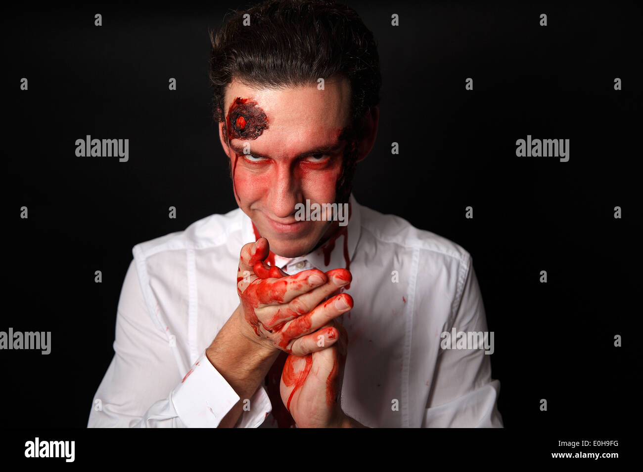 Psychopath with bloody hands in a white shirt Stock Photo