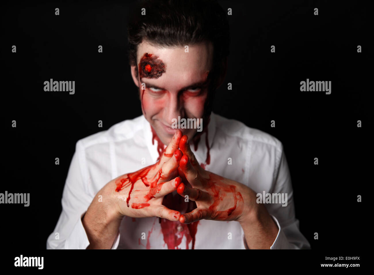 Psychopath with bloody hands in a white shirt Stock Photo