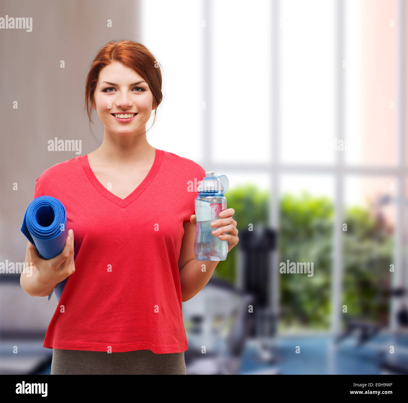 smiling girl with bottle of water after exercising Stock Photo - Alamy