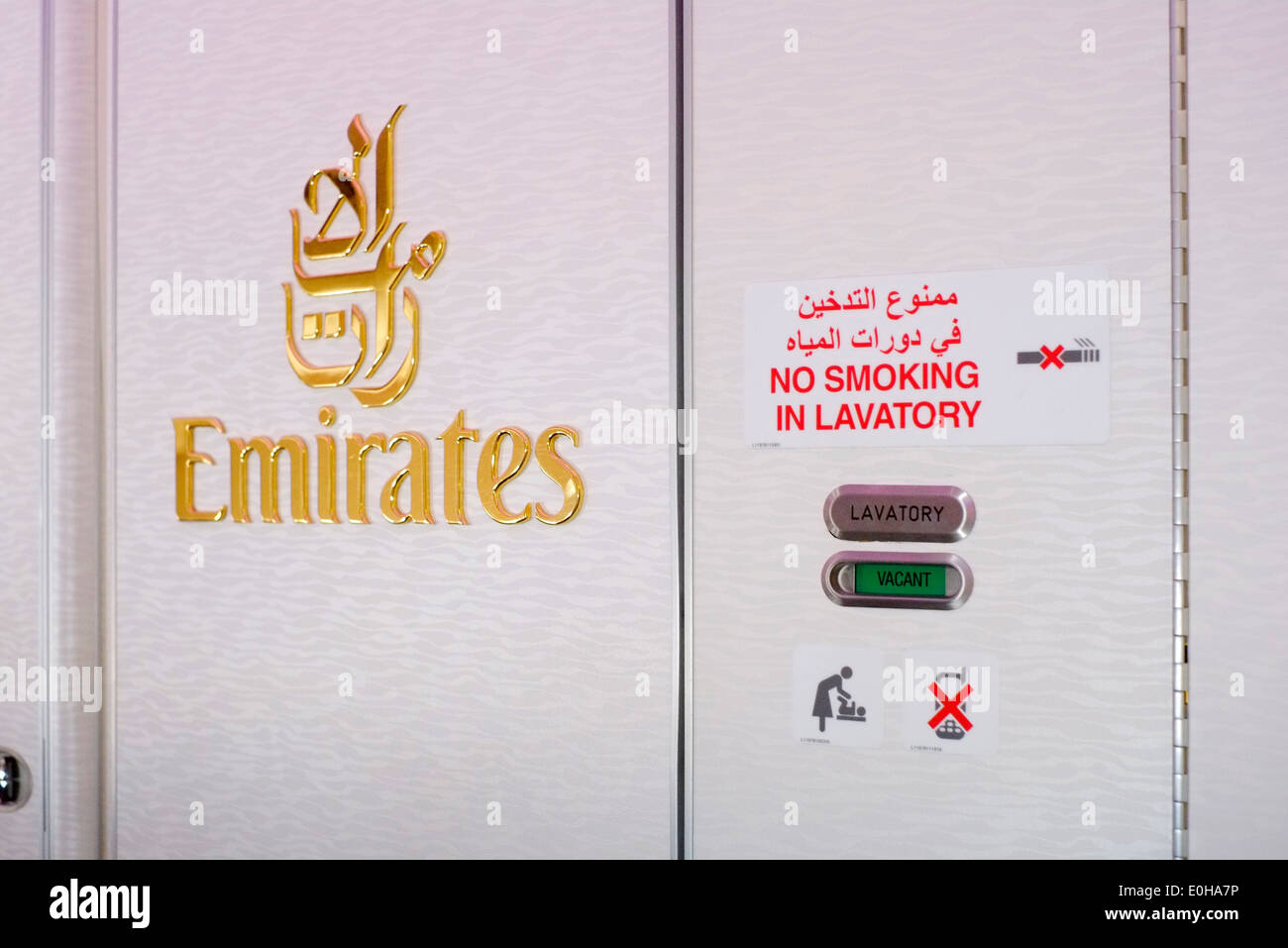emirates logo in gold on toilet door in the economy cabin of an emirates a380 airbus Stock Photo