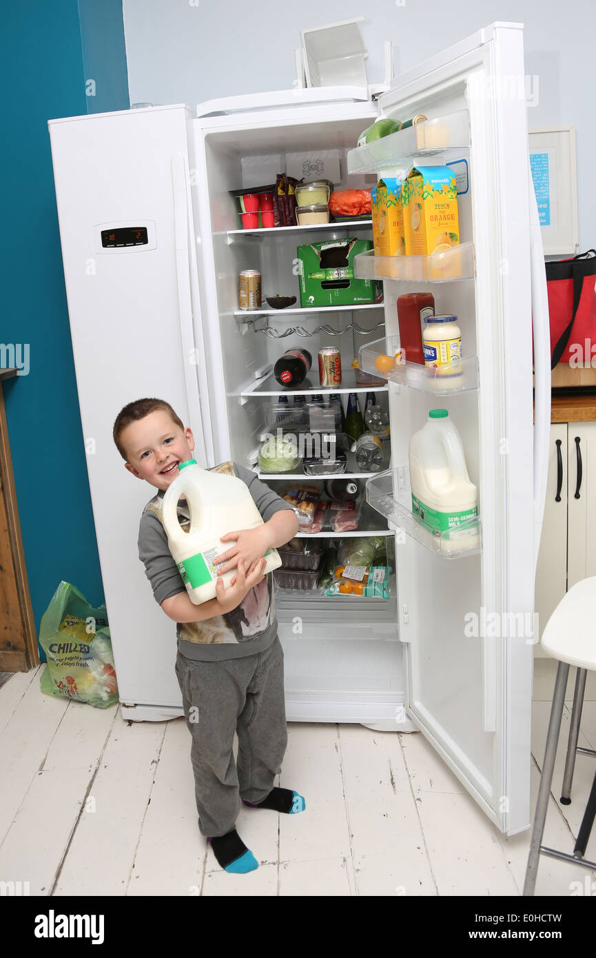Child getting milk from the fridge Stock Photo Alamy