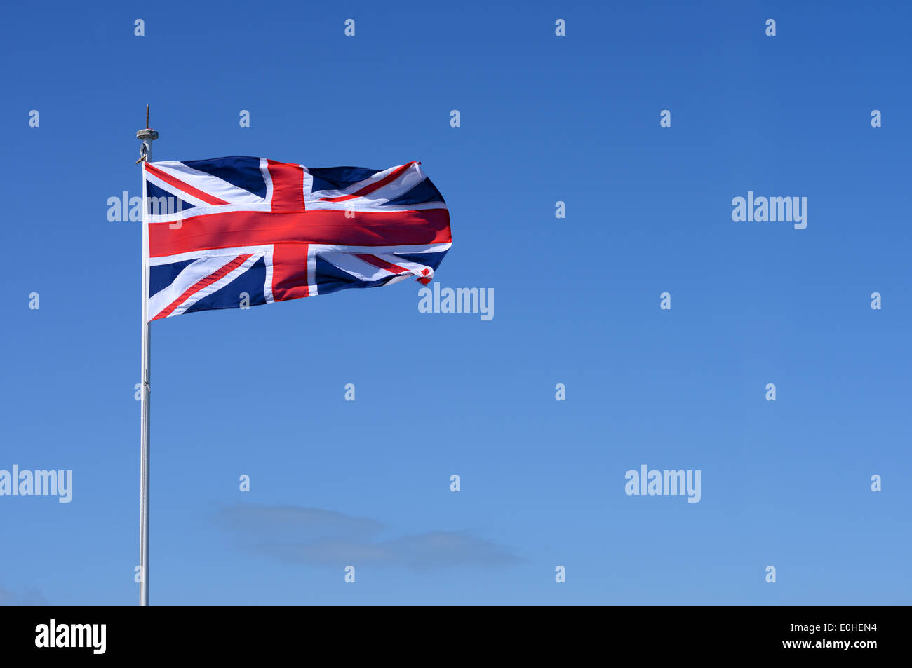 A Union Jack flag flying against a blue sky Stock Photo - Alamy