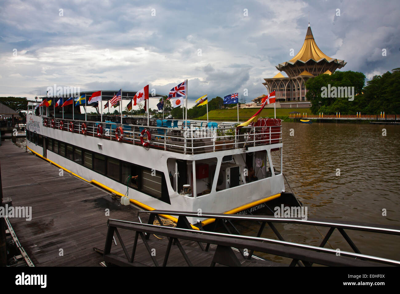 Tour boat and the SARAWAK STATE LEGISLATIVE ASSEMBLY as seen from the KUCHING RIVER - KUCHING,  BORNEO Stock Photo
