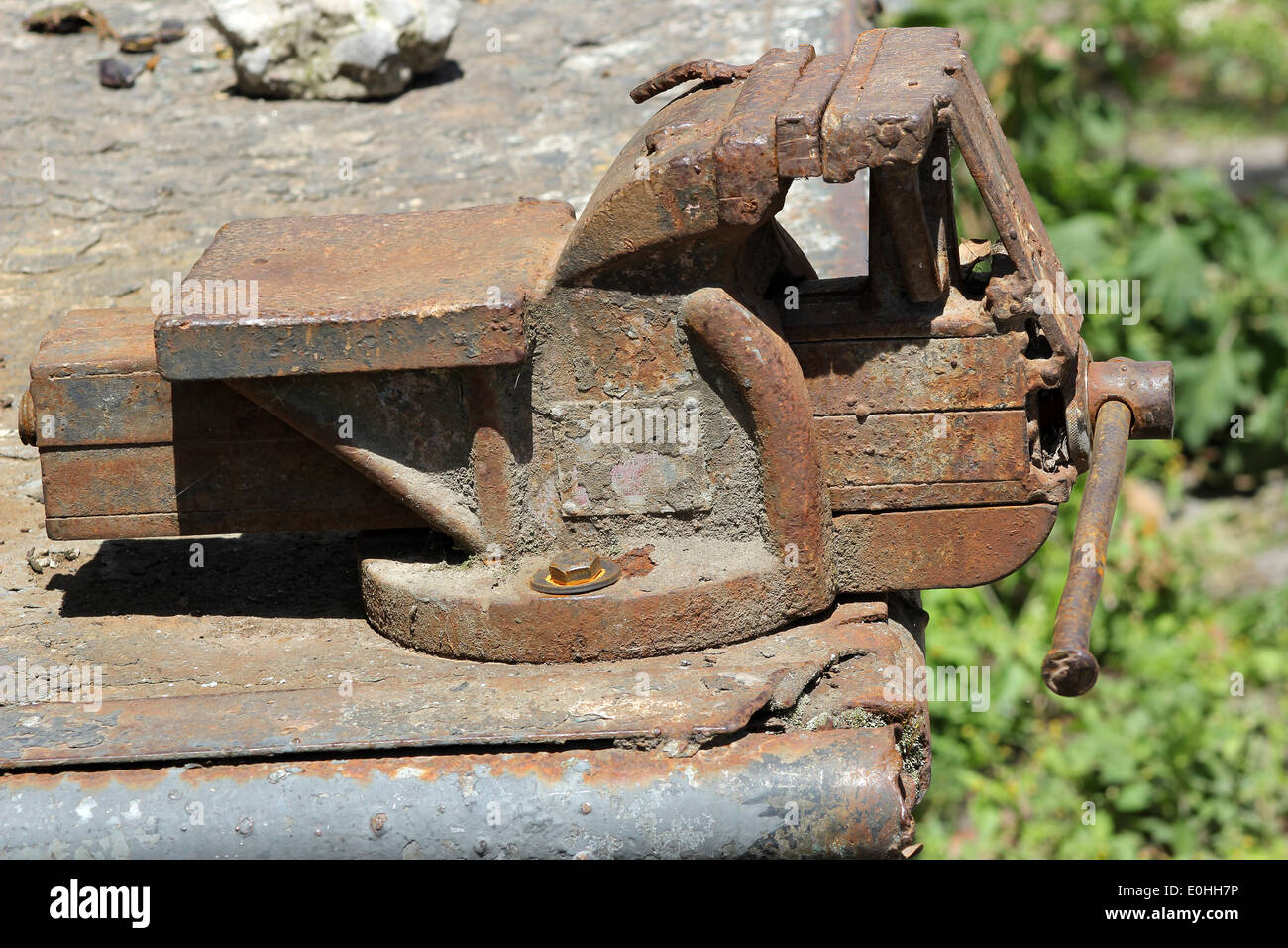 A rust covered cast iron vice on a steel table in Cotacachi, Ecuador Stock Photo