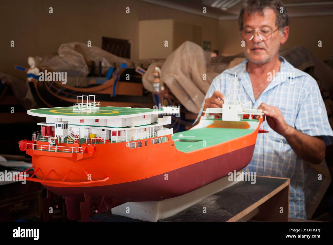 Employee works on a model ship of the DeBeers Diamond Mining ship at the Model Ship Builders, Mosselbay, South Africa Stock Photo