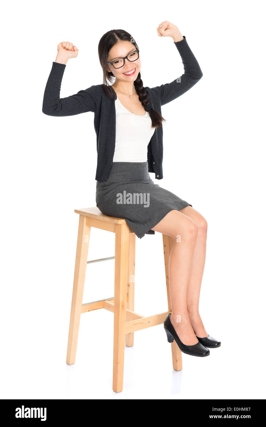 Full body Asian business woman seated on chair, arms raised celebrating  success isolated white background Stock Photo - Alamy