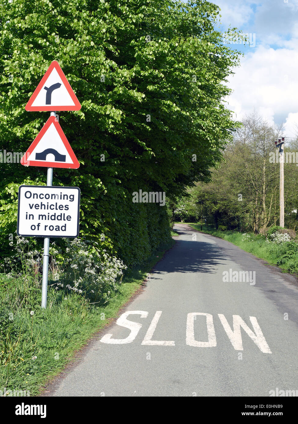 Road narrows sign Oncoming vehicles in middle of road in Cheshire UK Stock Photo