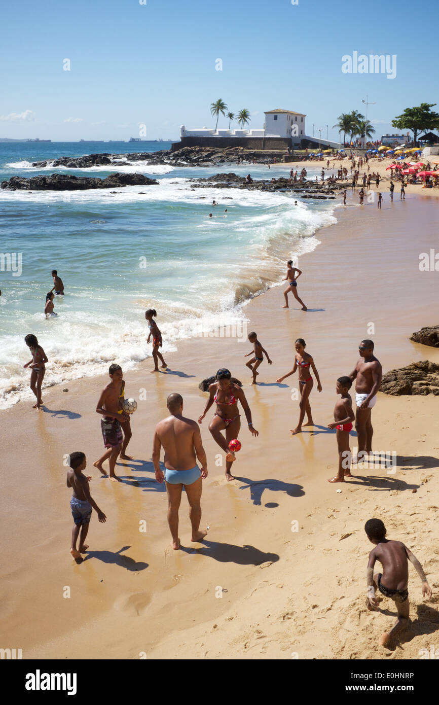 SALVADOR, BRAZIL - OCTOBER 13, 2013: Locals relax on Porto da Barra beach near the Fort Santa Maria. Stock Photo