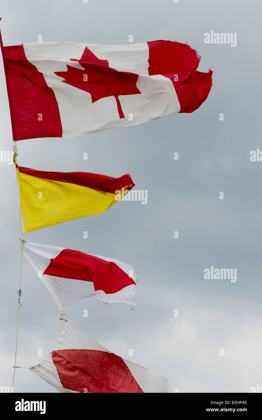 Low angle view of fluttering flags at Lobster Cove Head Lighthouse, Gros Morne National Park, Newfoundland And Labrador, Canada Stock Photo