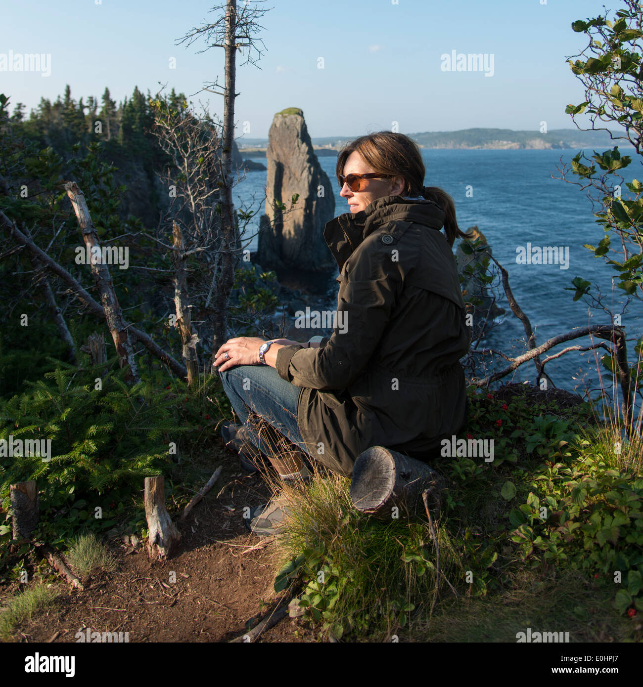 Woman sitting along Skerwink Trail, Port Rexton, Bonavista Peninsula