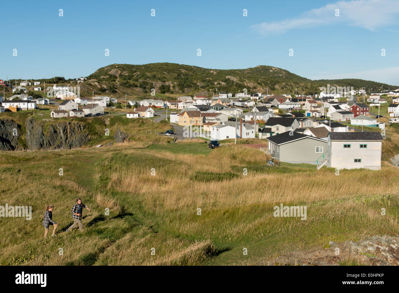 Girls walking through grass, North Twillingate Island, Newfoundland And Labrador, Canada Stock Photo