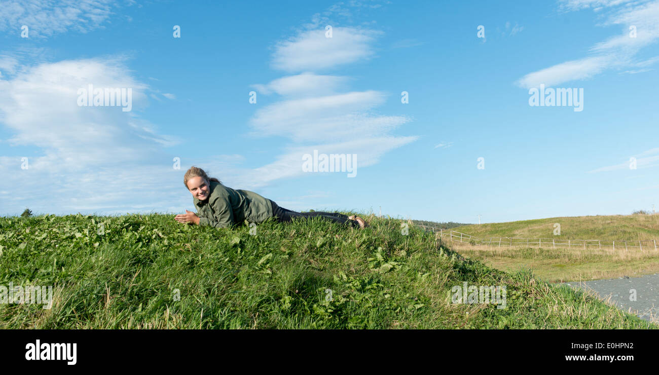 Girl lying on the grass, Witless Bay, Avalon Peninsula, Newfoundland And Labrador, Canada Stock Photo