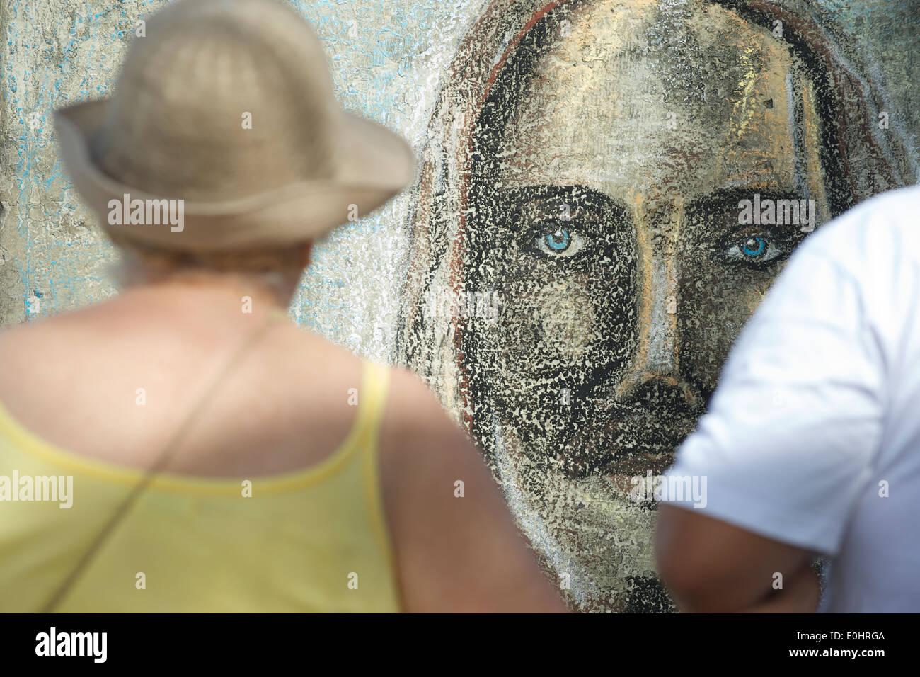 Tourists look at graffiti portrait of Christ the Redeemer at Arpoador, the capital of surf, skate, and graffiti culture in the c Stock Photo