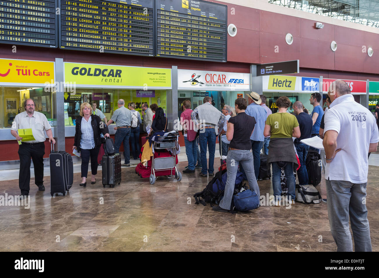 Passengers queuing at car rental desks in  Tenerifes Reina Sofia airport, Canary Islands, Spain. Stock Photo