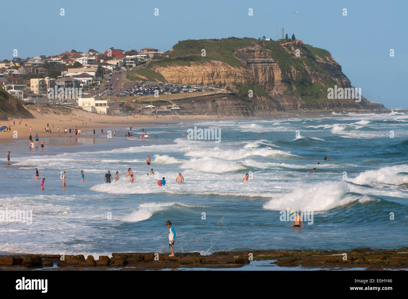 The waves role in on Bar beach Merewether, Newcastle, New South Wales, Australia as holiday makers enjoy the surf. Stock Photo