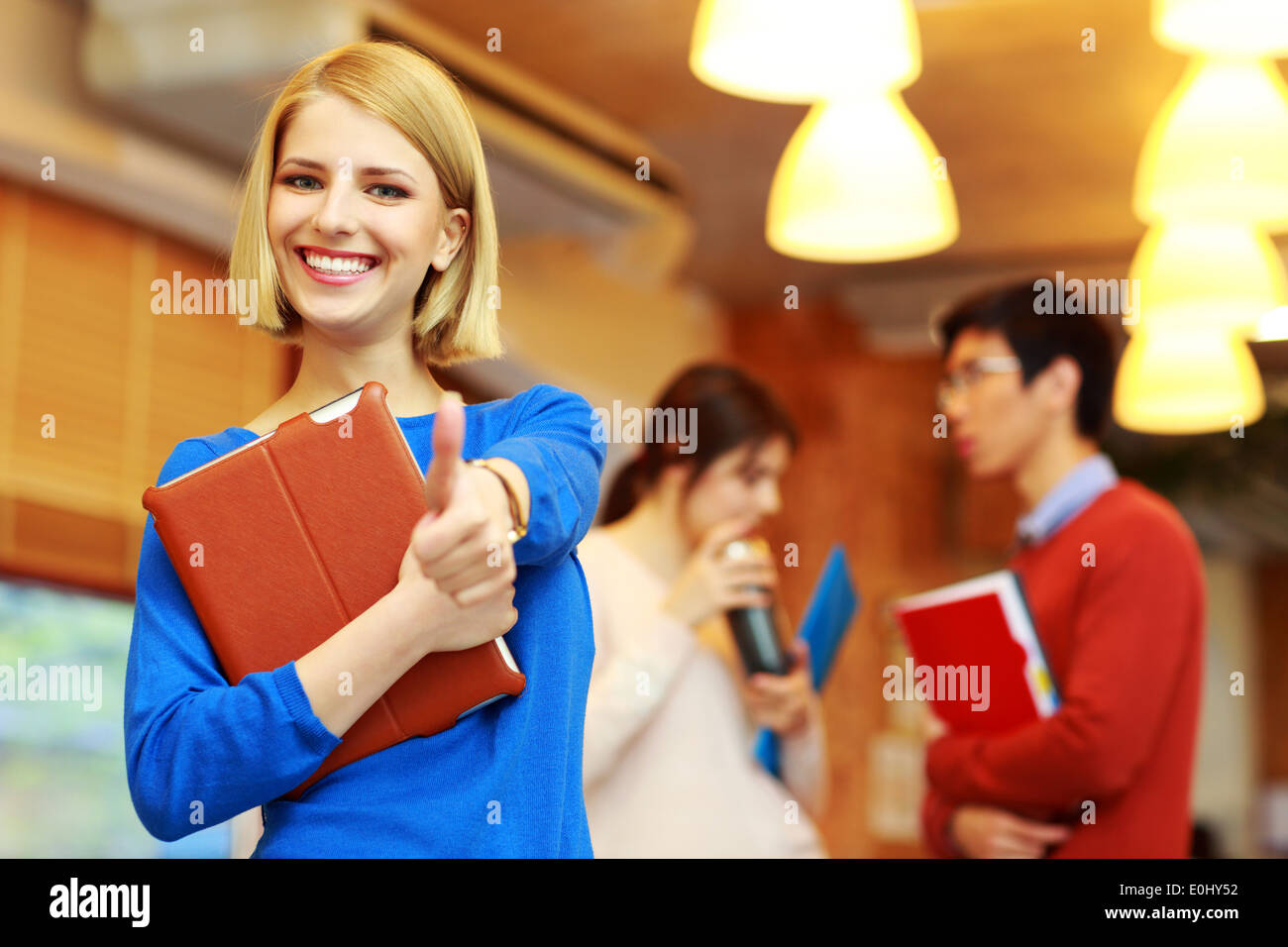 Happy female college student showing thumbs up Stock Photo - Alamy